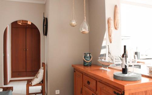 a kitchen with a wooden table with a bottle of wine at Lovely oceanview beach house in Portimão