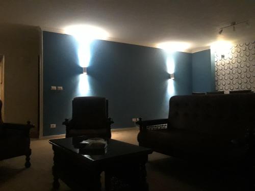 ein Wohnzimmer mit einem Sofa und zwei Lampen an der Wand in der Unterkunft Cheerful Spacious Apartment in Rehab City , Fully Equipped, Guest First Choice & Best Offer in The City مدينة الرحاب in Kairo