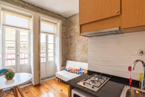 uma cozinha com um fogão e uma bancada em ZD Moreira Flats B By PortoProperties4You no Porto