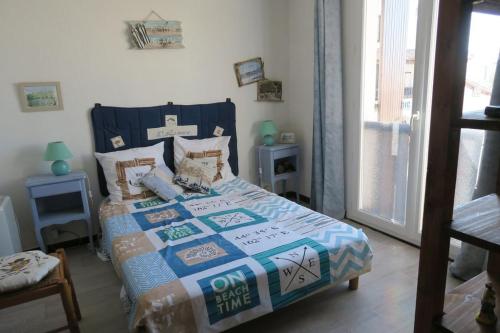 um quarto com uma cama com uma colcha em Appartement Camargue em Saintes-Maries-de-la-Mer