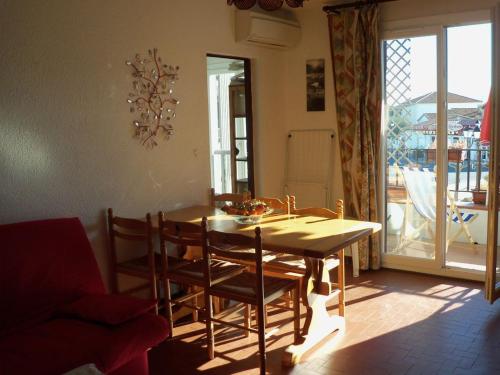 uma sala de jantar com mesa e cadeiras e uma varanda em Appartement Camargue em Saintes-Maries-de-la-Mer