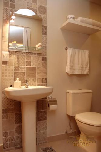 a bathroom with a sink and a toilet and a mirror at Casa Boutique Bèla Sofía in Asuncion