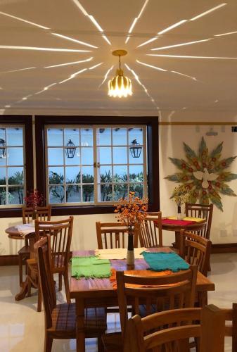 a dining room with a table and chairs and windows at Hotel Recanto do Ouro in Ouro Preto