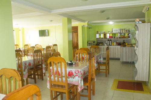 een eetkamer met tafels en stoelen en een keuken bij Palace Hotel Pôr do Sol in Vitória da Conquista