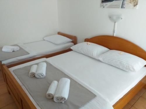 two beds in a room with white pillows at Apartments I-P in Malinska