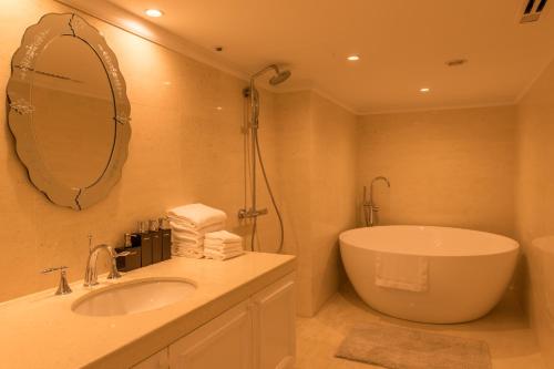 a bathroom with a tub and a sink and a mirror at IP City Hotel Osaka - Imperial Palace Group in Osaka