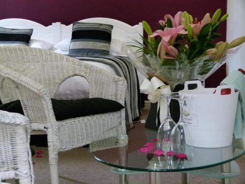 a room with a bed and a glass table with flowers at St John's Lodge incl off-site leisure club in Windermere