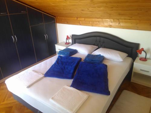 a bedroom with a bed with blue pillows on it at Viki in Kastav