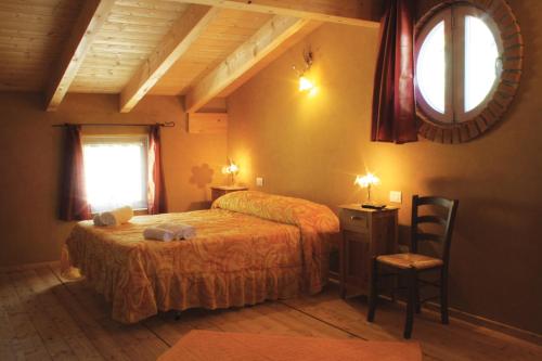 a bedroom with a bed and a window and a chair at B&B Al Cristo in SantʼAmbrogio di Valpolicella