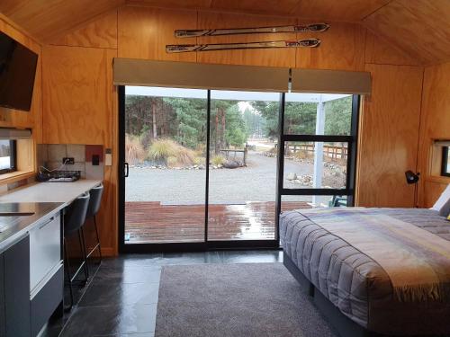 a bedroom with a bed and a large sliding glass door at The Rest in Twizel