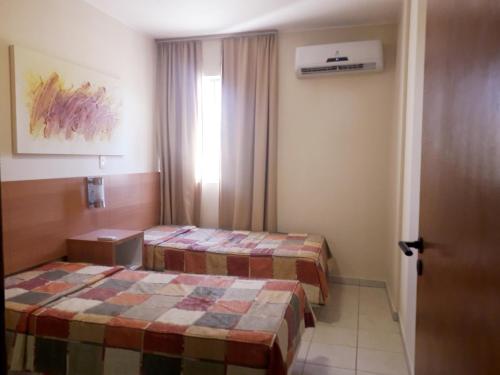 a hotel room with two beds and a door at AP532 Thermas Paradise Cobertura Duplex 2 quartos in Rio Quente