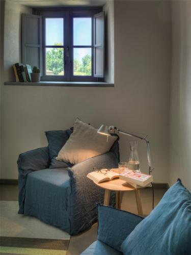 a living room with a blue couch and a table at Locanda Dei Nobili Viaggiatori in Cavernago