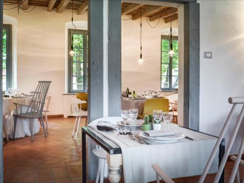 ein Esszimmer mit einem Tisch mit Tellern und Gläsern in der Unterkunft Locanda Dei Nobili Viaggiatori in Cavernago