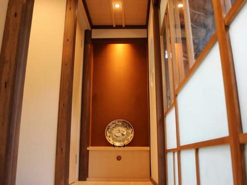 a clock sitting on a shelf next to a window at Katsuemon in Gose