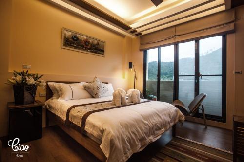 a bedroom with a bed and a large window at Ciao Home in Toucheng