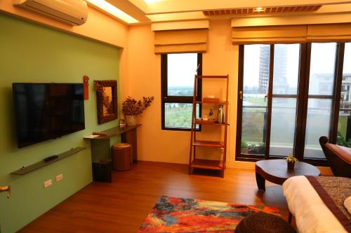 a living room with a couch and a flat screen tv at Ciao Home in Toucheng