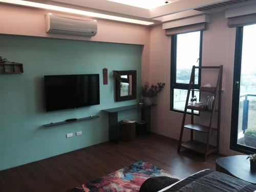 a living room with a flat screen tv on a wall at Ciao Home in Toucheng