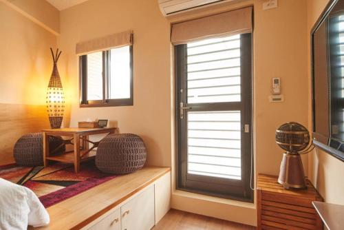 a room with a table and a window with a desk at Ciao Home in Toucheng