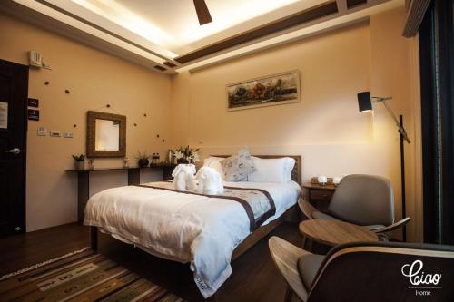 a bedroom with a bed with two stuffed animals on it at Ciao Home in Toucheng