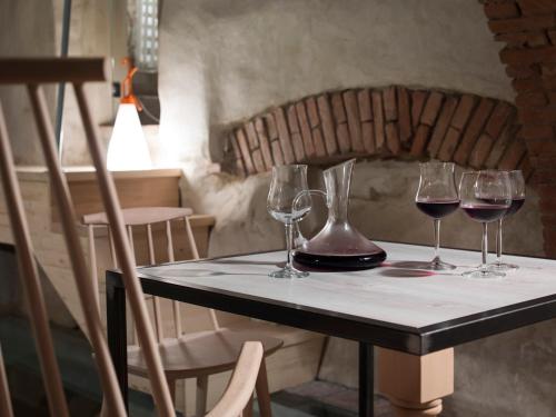 a table with four wine glasses on it at Locanda Dei Nobili Viaggiatori in Cavernago