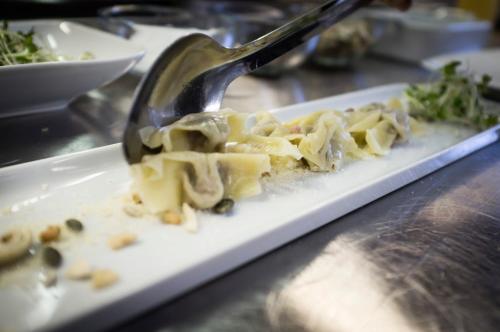 a fork digging into a plate of food with pasta at Locanda Dei Nobili Viaggiatori in Cavernago