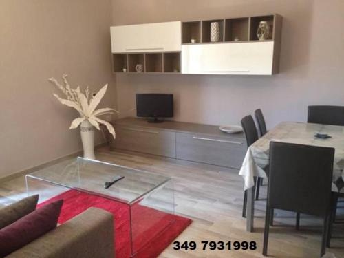 a living room with a glass table and a dining room at Fiordaliso in Caulonia Marina