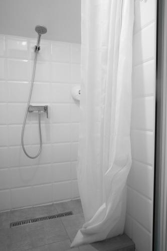 a shower with a shower curtain in a bathroom at Good People Design Hostel in Belgrade