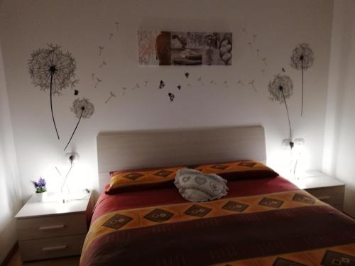 een slaapkamer met een bed met paardenbloemen aan de muur bij Cà delle Rose in Rovereto