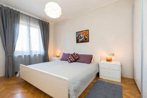 a white bedroom with a large bed and a window at Comfort Premium Apartment in Poreč