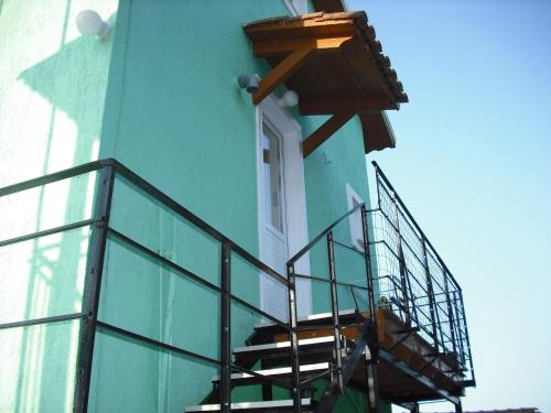 a blue building with stairs leading to a window at ΣΑΡΑΝΤΗΣ ΜΑΡΚΌΠΟΥΛΟς in Lakithra