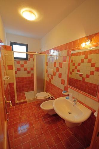 a bathroom with two toilets and a sink and a shower at Abbaidda Hotel in Valledoria