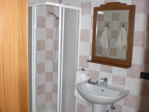 a bathroom with a sink and a shower with a mirror at Hotel Sirios in San Giovanni Rotondo