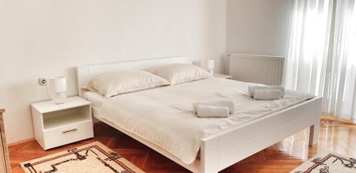 1 cama blanca con 2 almohadas en el dormitorio en Apartman Lucija, en Livno