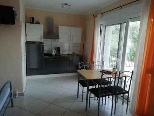 a kitchen and dining room with a table and chairs at Studios Oleander in Limenaria