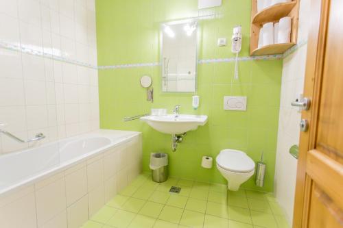 a green bathroom with a sink and a toilet at Apartmajsko naselje Ribniško Pohorje in Ribnica na Pohorju