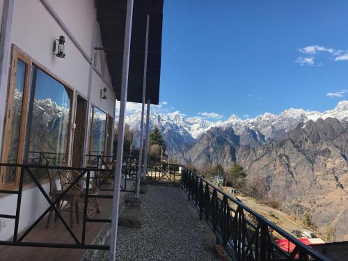 a balcony of a building with a view of mountains at Mountain Rover Auli Resort in Joshīmath