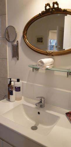 a bathroom with a sink with a mirror and a mirror at Astley Cottage in Daylesford