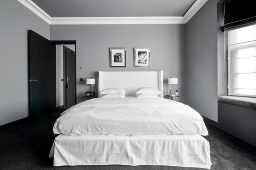 a bedroom with a large white bed with two pillows at Hotel Odette en Ville in Brussels