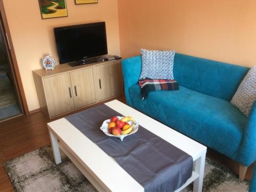 a living room with a blue couch and a bowl of fruit at gemuetliche unterkunft bei prag in Smečno