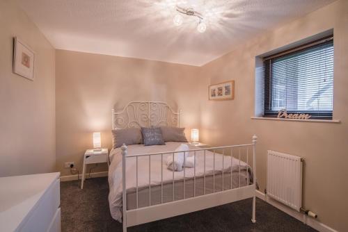 een slaapkamer met een wit bed en een raam bij SEC/ Hydro Two Bed Flat With Free parking and Great View in Glasgow