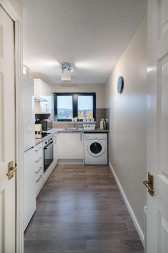 a white kitchen with a sink and a dishwasher at ArcView - SEC Hydro Two Bed Flat With Free parking and Great View in Glasgow