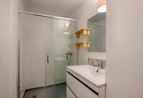 a white bathroom with a sink and a shower at Casa Elettra in Rhodes Town