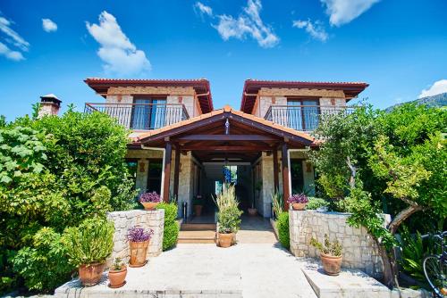 a house with a stone entrance with potted plants at Renka Hotel & Spa in Göcek