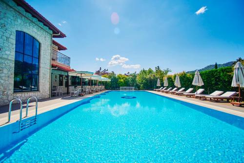 une grande piscine avec des chaises et des parasols dans l'établissement Renka Hotel & Spa, à Göcek