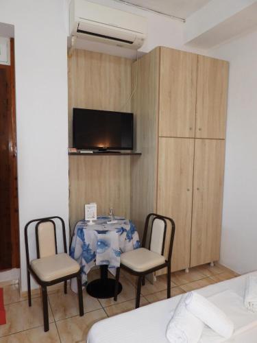 a room with a table and two chairs and a tv at Kanali Beach House 2 in Kanali