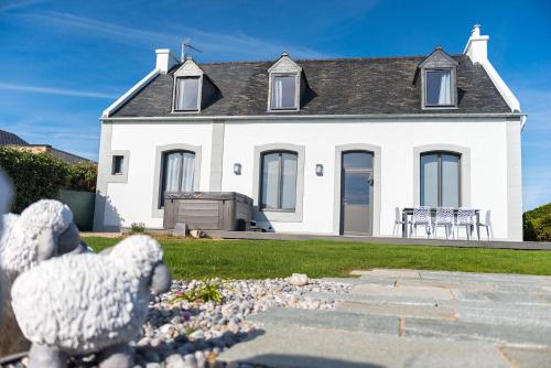 a white teddy bear in front of a white house at Le Clos de la Pointe Saint-Mathieu in Plougonvelin