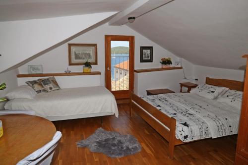 a bedroom with two beds and a balcony at Studios Jacobus in Korčula