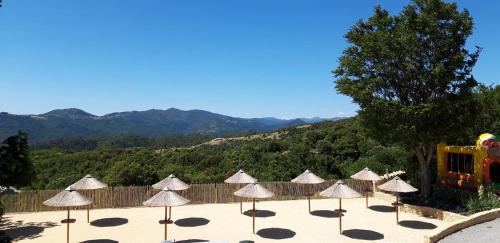 a group of umbrellas on a patio with mountains in the background at Domaine Plein Sud in Bruzac