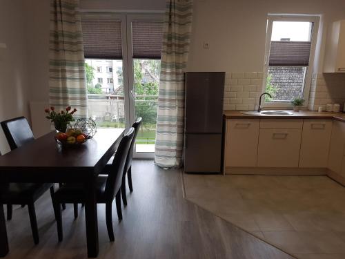 a kitchen with a table with a bowl of fruit on it at Narutowicza Modern Apartment in Słupsk