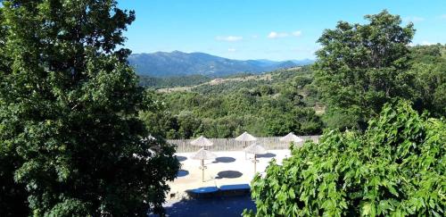 a view of a pool with umbrellas and water at Domaine Plein Sud in Bruzac